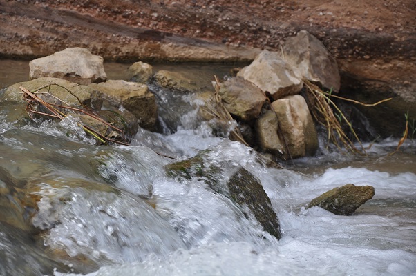 Stromend rivierwater tijdens kloofwandeling Wadi El Hasa tijdens een wandelreis van SNP door Jordanië