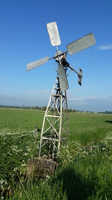 Wandelen over het Grebbeliniepad bij een windmolentje langs het Valleikanaal