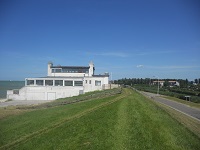 Wandelen over het Groot Frieslandpad langs strandpaviljoen op dijk IJsselmeer in Hindeloopen