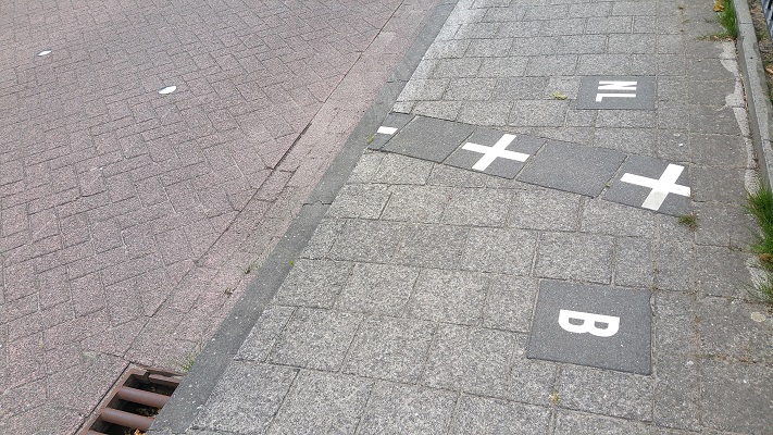 Wandelen over het Hugo de Grootpad bij straatplan in Baarle-Hertog
