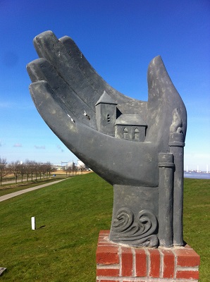 Hand uit de zeedijk, monument ter nagedachtenis aan het kerkje van Oterdum tijdens een wandeling over het Nederlands Kustpad van Termunterzijl naar Delfzijl