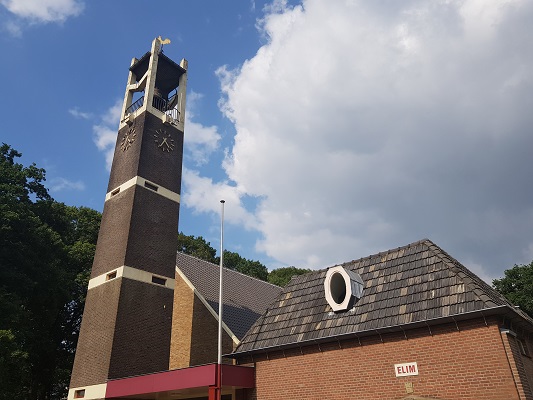 Wandelen over het Westerborkpad van 't Harde naar Elburg bij kerk in 't Harde