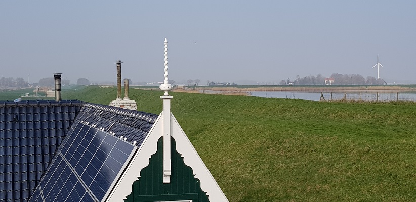 Wandelen over het Noord-Hollandpad van Nieuwesluis naar Den Oever bij een versiering op het dak van een boerderij