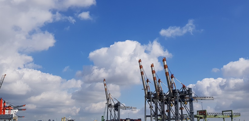 Wandeling buiten de binnenstad van Rotterdam over het Heiplaatpad bij hijskranen bij containerterminal